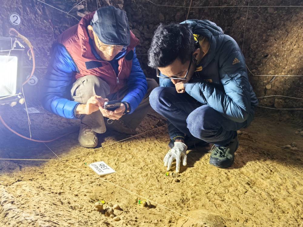Malaysian fossil scientist Dr Paul Rummy, together with 93-year-old paleontologist Dr Huang Wanpo, examines traces of two-million-year-old coprolites (fossilised excreta) at Longgupo, also known as Dragon Bone Cave, in Wushan, China. Photo by Bernama