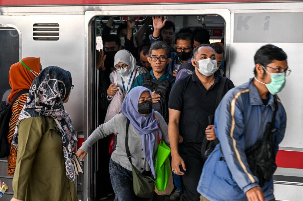 This picture taken on November 8, 2024 shows commuters leaving a commuter train during the morning rush hour at Manggarai station in Jakarta. (Photo by BAY ISMOYO/AFP)