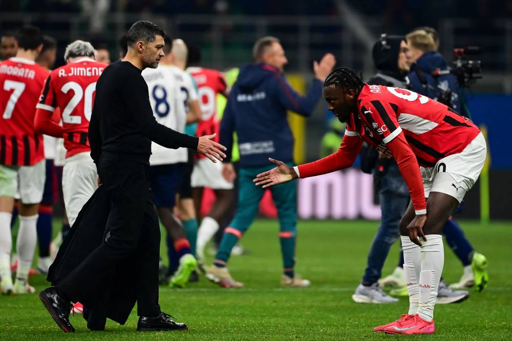 AC Milan's US forward Tammy Abraham (R) shakes hands with AC Milan's Portuguese coach Sergio Conceicao at the end of the Italian Serie A football match between AC Milan and Cagliari at the San Siro Stadium in Milan, Italy on January 11, 2025. (Photo by Piero CRUCIATTI / AFP)