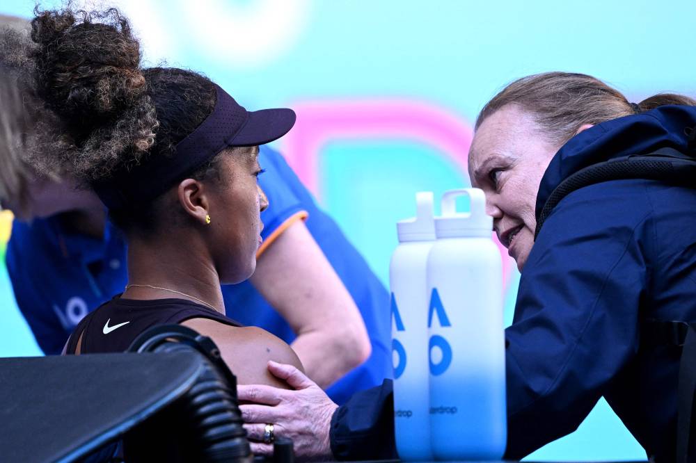 Japan's Naomi Osaka receives medical attention during her women's singles match against Switzerland's Belinda Bencic on day six of the Australian Open tennis tournament in Melbourne on January 17, 2025. (Photo by WILLIAM WEST/AFP)