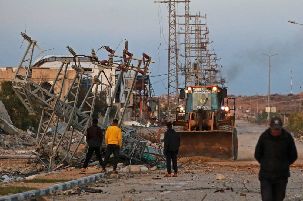 A bulldozer clears debris off the Salah al-Din main road through the Gaza Strip, north of Nuseirat in the centre of the Palestinian territory on January 19, 2025. (Photo by Bashar TALEB / AFP)