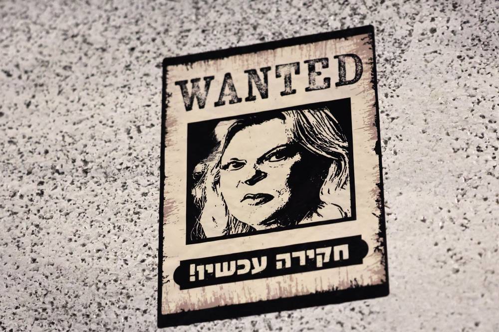 A poster depicting Israeli Prime Minister's wife Sara Netanyahu, with a slogan in Hebrew which reads 'investigation now' is pictured, in front of the Israeli Defence Ministry in Tel Aviv. Photo by Jack GUEZ/AFP FILE PIX