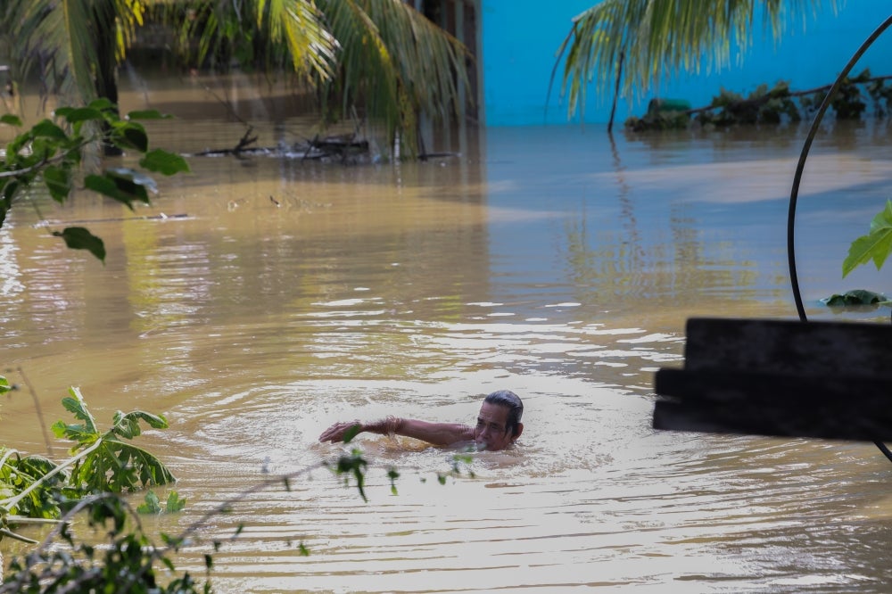 A man seen swimming in floodwater at Kampung Gana Jati, Telupid, Sabah.