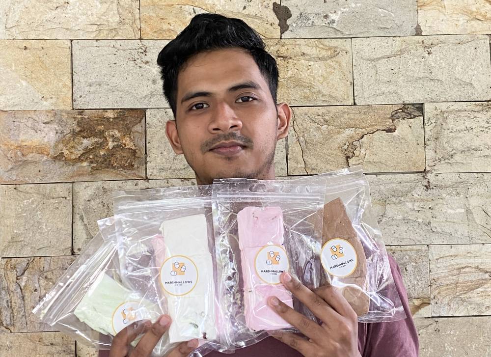 Nur Ikhmal Danial Zakaria showing the halal marshmallows he sells. Photo by Bernama