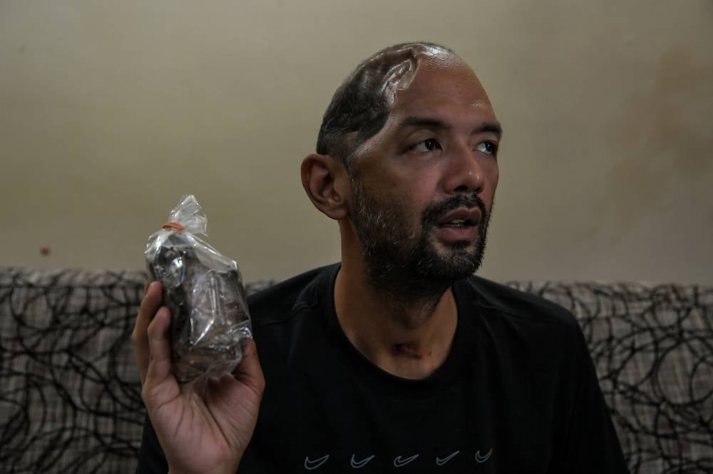 Muhammad Sufi Abdul Aziz,36 showing some of the smoked beef he prepared. Photo by Bernama