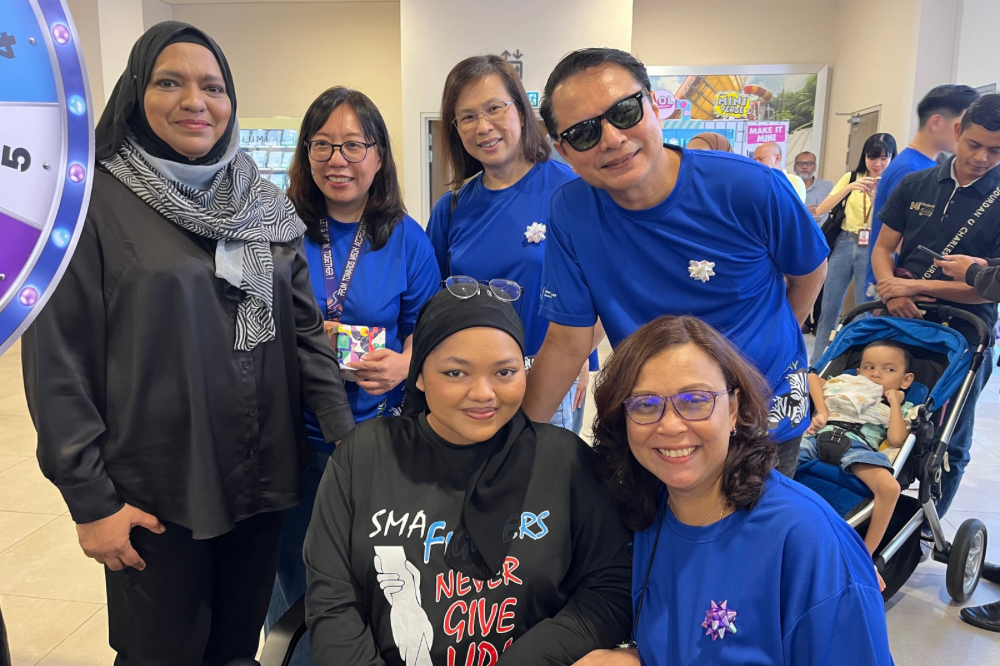 SMA Type 2 Patient, Miza Marsya Roslan (centre, on a wheelchair) with UMMC’s Rare Disease Awareness event’s committees on Feb 22 at Sunway Velocity Mall.