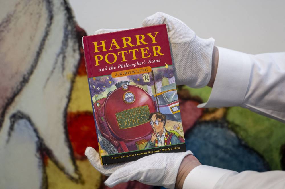 An art handler holds an example of the first hardback issue of the first edition Harry Potter book, one of only 500 copies at Sotheby’s, in New York on June 25, 2024. - (Photo by ANGELA WEISS / AFP)