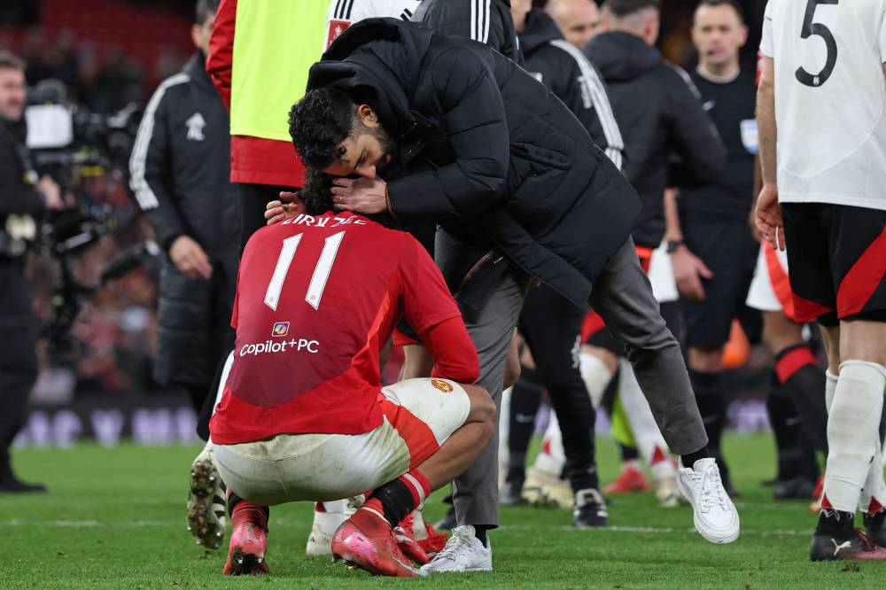 Manchester United's Dutch striker Joshua Zirkzee is consoled by Manchester United's Portuguese head coach Ruben Amorim after missing the final penalty in the penalty shoot-out in the English FA Cup fifth round football match between Manchester United and Fulham at Old Trafford in Manchester, north west England, on March 2, 2025. Fulham won the game 4-3 on penalties after finishing 1-1 after extra time. (Photo by Darren Staples / AFP)