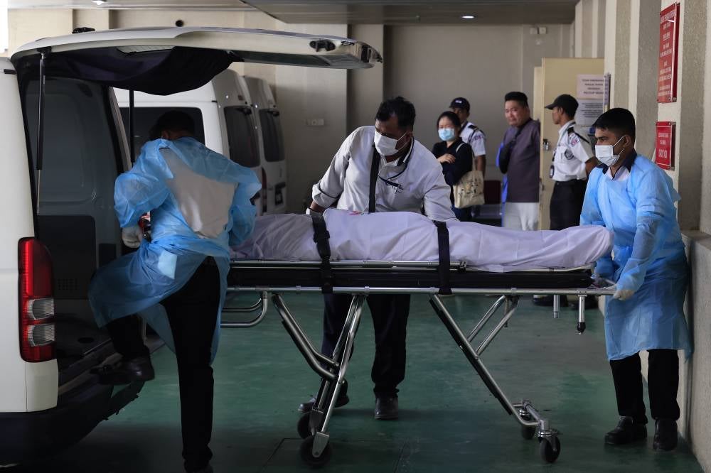 The body of a Customs Tribunal officer is taken out of the Forensic Department at Putrajaya Hospital after being claimed by family members for transfer to Nirvana Memorial Centre, Sungai Besi, for burial arrangements, today. - Photo by Bernama