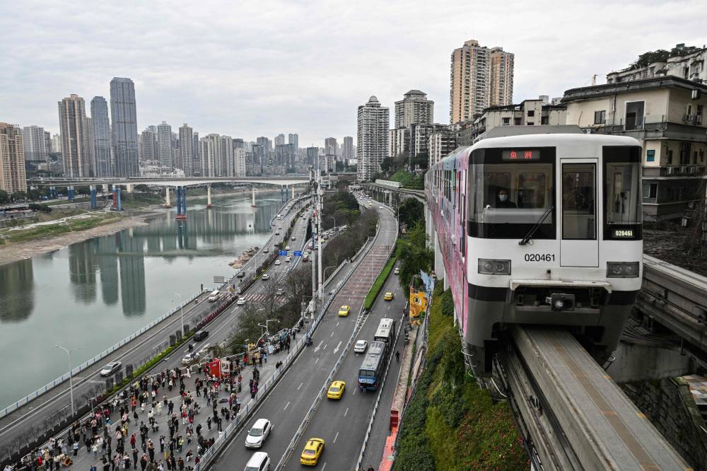 A train arrives at the Liziba monorail station located in a residential building in Yuzhong district in Chongqing in southwestern China on March 6, 2025. (Photo by Hector RETAMAL/AFP)