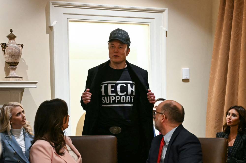 Leader of the Department of Government Efficiency Elon Musk wears a shirt that says "Tech Support" as he speaks during a cabinet meeting with US President Donald Trump at the White House in Washington, DC, on February 26, 2025. Elon Musk said X was hit by a "massive" cyberattack on March 10, 2025, as outages plagued users of the platform once known as Twitter. Musk blamed a cyberattack, providing no evidence, for crashing the site last year when an interview with Donald Trump was to be streamed. (Photo by Jim WATSON / AFP)