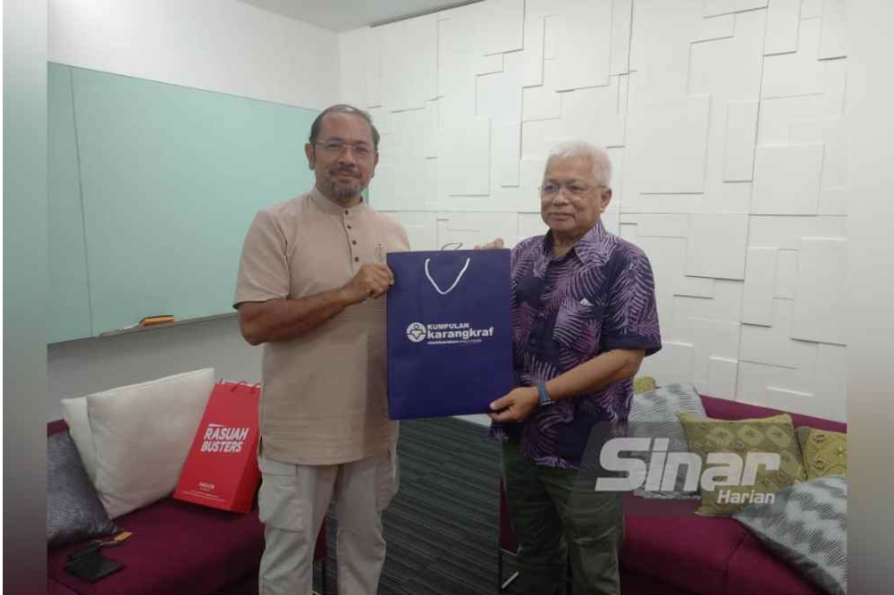 Karangkraf Group adviser Datuk Hussamuddin Yaacub (right) presenting a souvenir to IIM board member Datuk Seri Mustafar Ali after the discussion between both parties.