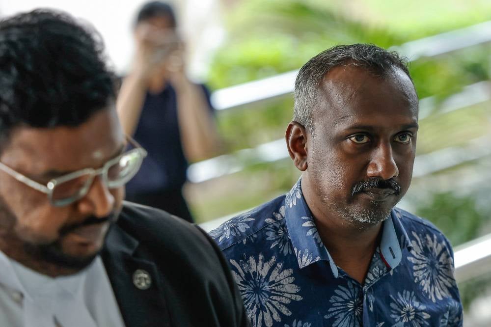 Journalist B Nantha Kumar, 42, (right) pleaded not guilty in the Sessions Court to a charge of receiving an RM20,000 bribe. - Photo by Bernama