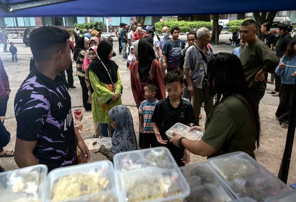 The asnaf community collected food supplies distributed by non-governmental organisations (NGOs) as their iftar meal at Lorong Haji Taib, Chow Kit, recently. Photo by Bernama