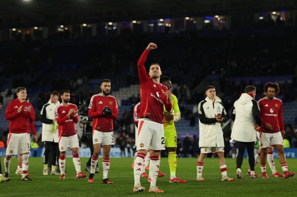 Manchester United's Portuguese defender #20 Diogo Dalot (C) and teammates celebrate on the pitch after the English Premier League football match between Leicester City and Manchester United at King Power Stadium in Leicester, central England on March 16, 2025. Manchester United won the game 3-0. (Photo by Adrian Dennis / AFP) / RESTRICTED TO EDITORIAL USE. No use with unauthorized audio, video, data, fixture lists, club/league logos or 'live' services. Online in-match use limited to 120 images. An additional 40 images may be used in extra time. No video emulation. Social media in-match use limited to 120 images. An additional 40 images may be used in extra time. No use in betting publications, games or single club/league/player publications. /