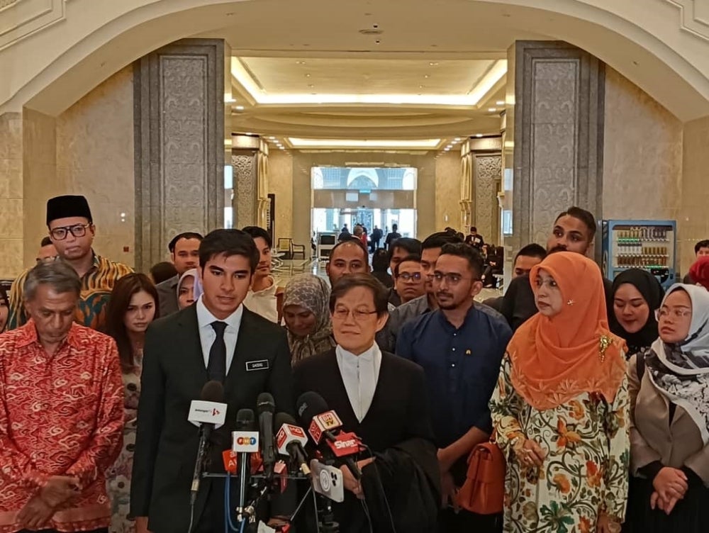 Senior lawyer Datuk Hisyam Teh Poh Teik (centre) alongside Syed Saddiq after the appeal proceedings, on Wednesday.
