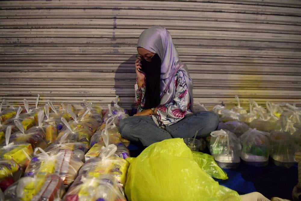 Sahur With Homeless Project volunteer pack food to be given to the homeless around Ipoh. Photo by Bernama