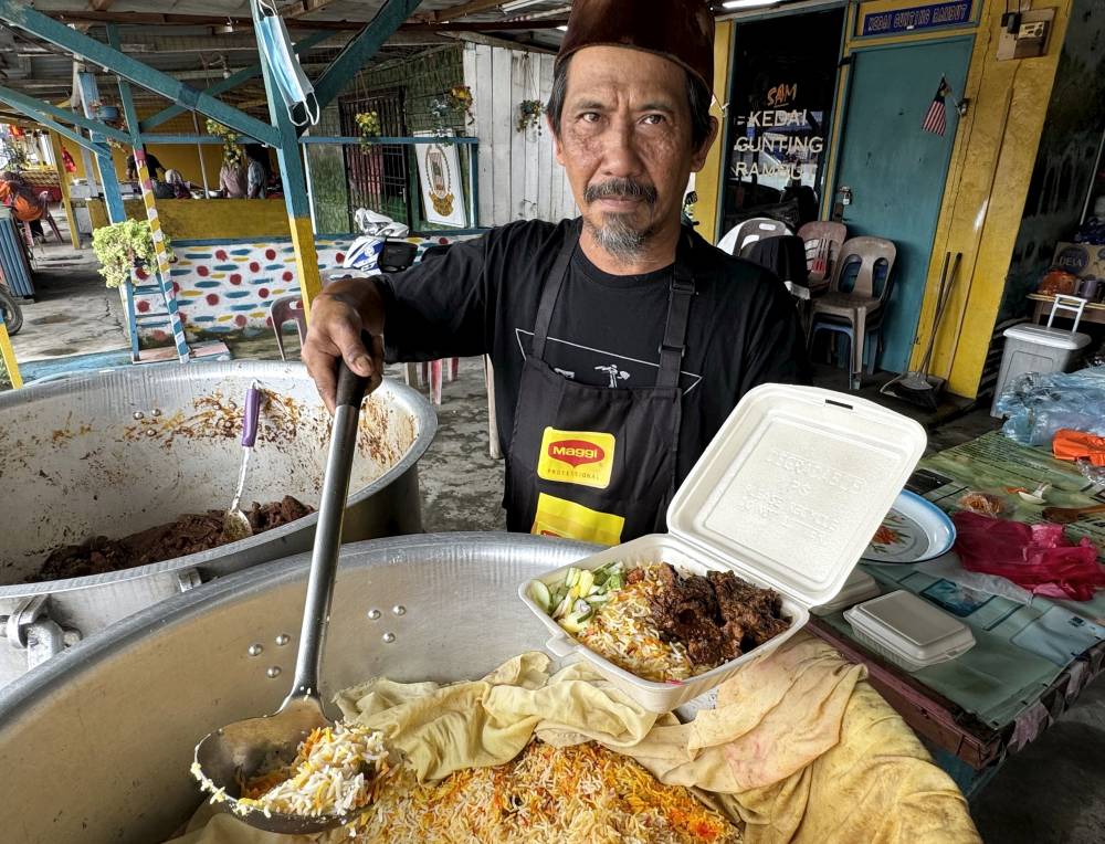 Nasi Beriani Gam Klasik entrepreneur Basir Hasan packing his customers' order. Photo by Bernama