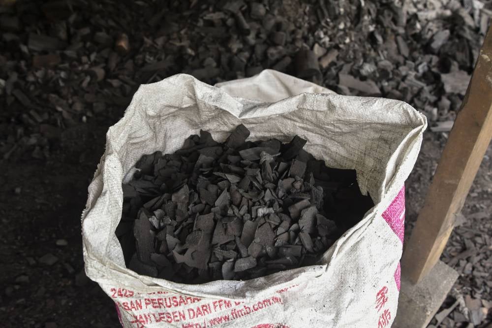 Charcoal is sold at RM40 per sack, while in plastic packaging, it is priced at RM3 per packet. Photo by Bernaa