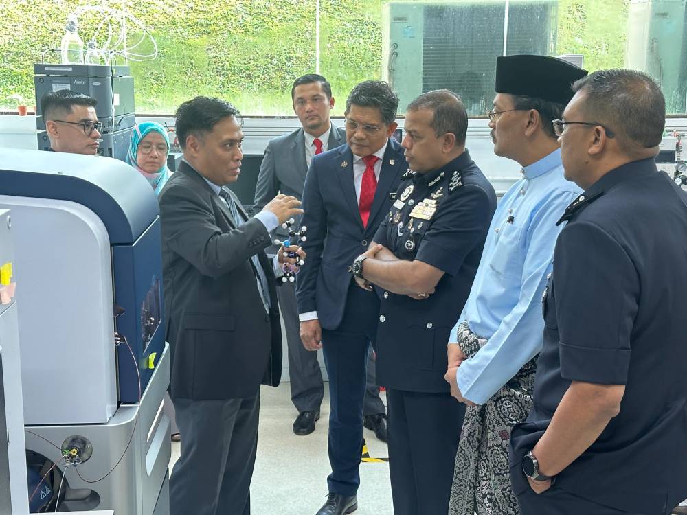 Ayob Khan (third from the right) inspects UKM's forensic laboratory, which analyses various types of drugs and chemicals.