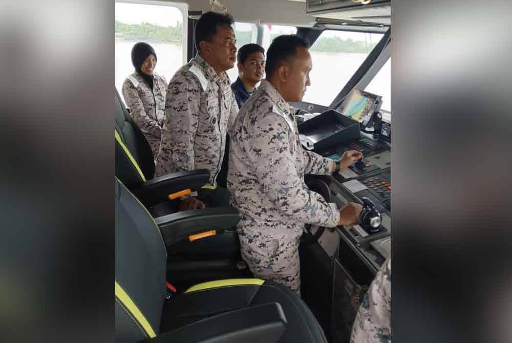 Zali (second from left) takes on the task of captaining the KM Nyalau ship to ensure that the country's waters remains secure.