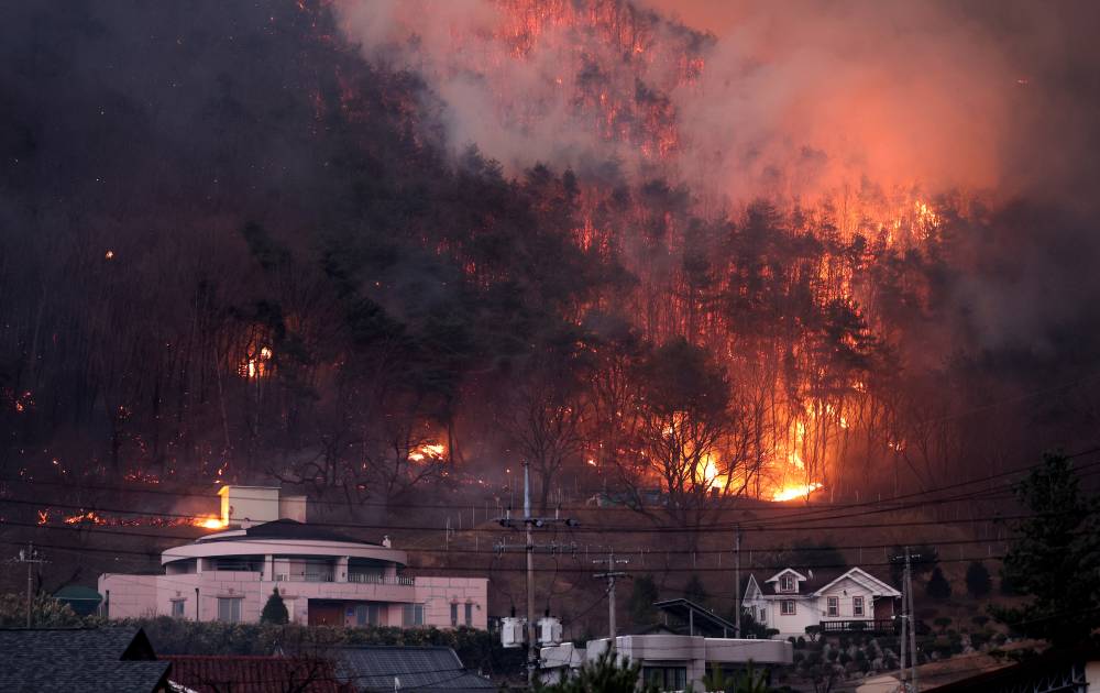 This photo taken on March 25, 2025 shows the wildfire spreading to local villages in Andong, North Gyeongsang Province, South Korea. (NEWSIS via Xinhua)