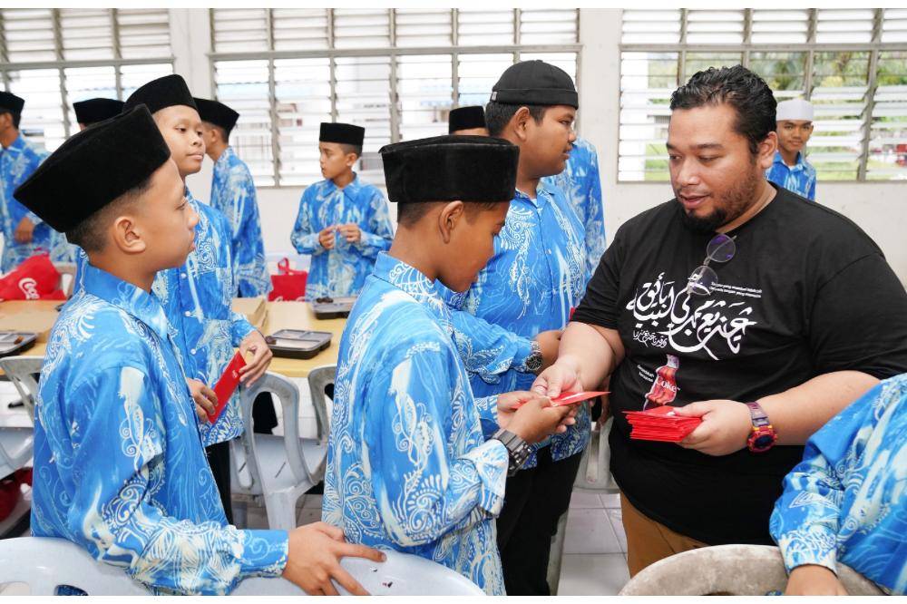 YBK’s Asrama Kasih students receiving their ‘duit raya’ from Coca-Cola Malaysia.