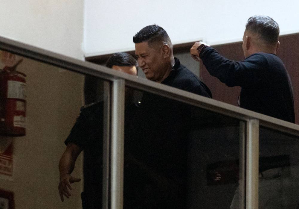 Julio Coria, former security of late Argentine football legend Diego Maradona, is escorted after being detained for false testimony at the San Isidro court in San Isidro, Buenos Aires province, Argentina, on March 25, 2025. Seven medical professionals who cared for Argentine football legend Diego Maradona during his final days go on trial accused of criminal negligence over his death. Maradona died on November 25, 2020 aged 60 while recovering from brain surgery for a blood clot, after decades battling cocaine and alcohol addictions. (Photo by Tomas CUESTA/AFP)