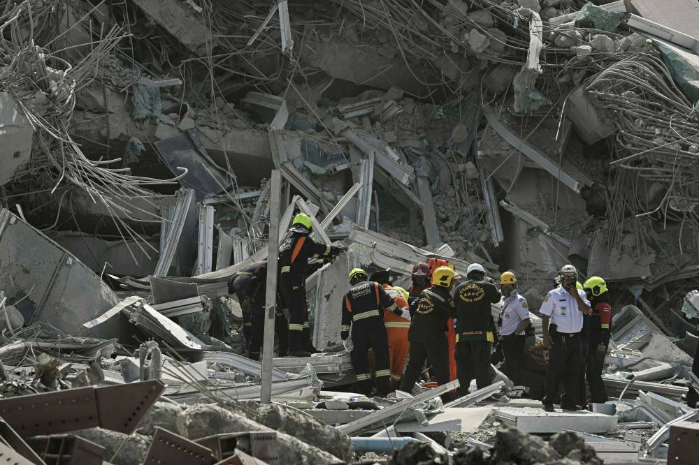Rescue teams are seen at a construction site where a building collapsed in Bangkok after an earthquake. Photo by Lillian Suwanrumpha/AFP