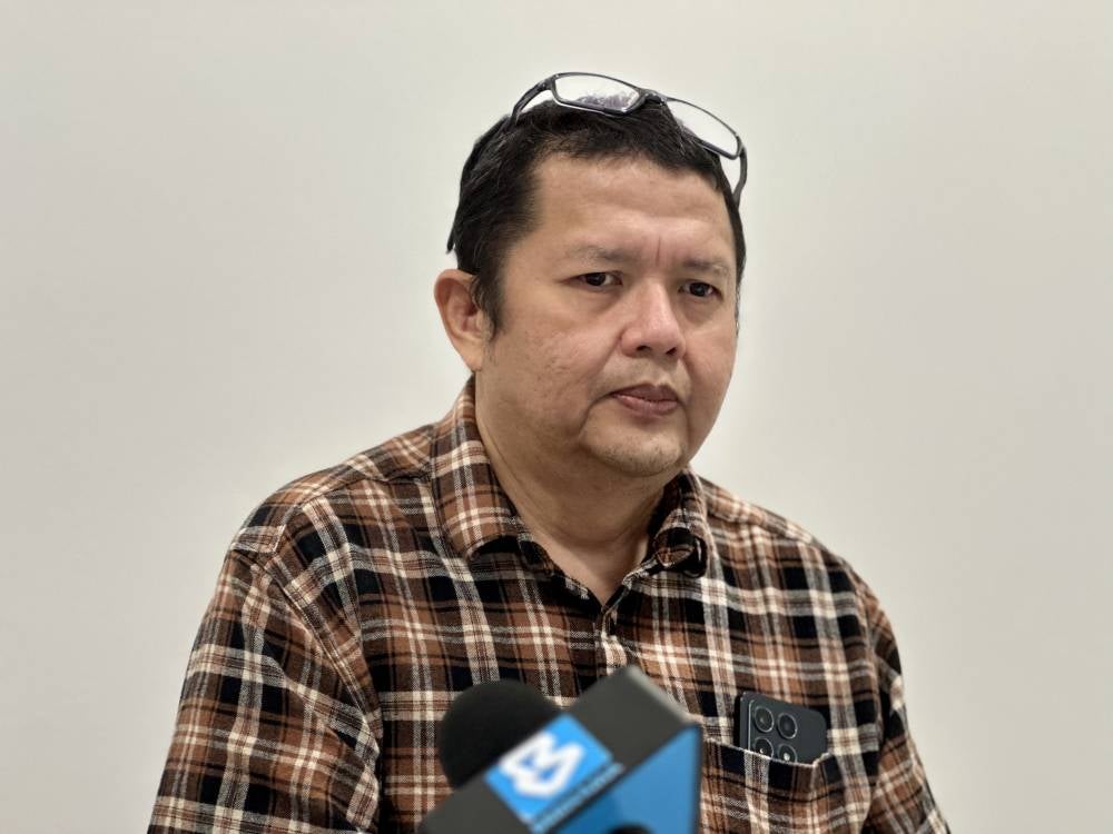 Azman Ahmad Bakri, 49, father of his son, Mikhael Azman, 13, who suffers from Prader-Willi Syndrome (PWS), a rare genetic condition in Malaysia.
Photo by Bernama