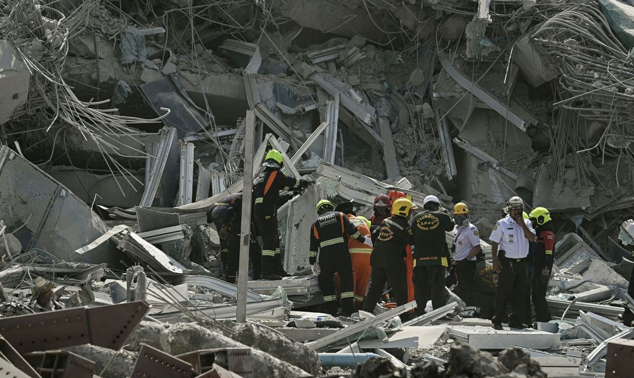 Rescue teams are seen at the site of the collapsed building. Photo by AFP