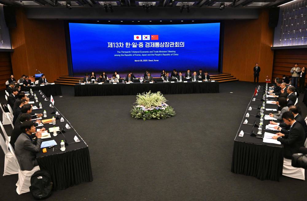 South Korea's Trade, Industry and Energy Minister Ahn Duk-geun (C), Japan's Economy, Trade and Industry Minister Yoji Muto (L) and China's Commerce Minister Wang Wentao attend at the 13th Trilateral Economic and Trade Ministers' Meeting in Seoul on March 30, 2025. (Photo by Jung Yeon-je / AFP)