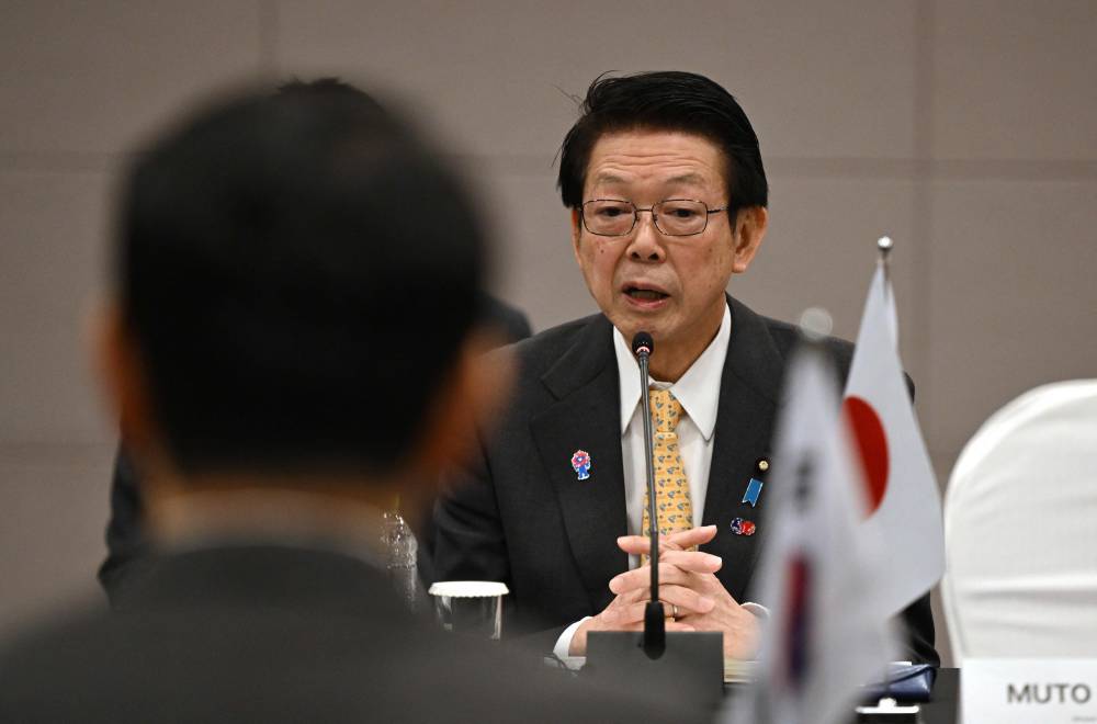 Japan's Economy, Trade and Industry Minister Yoji Muto (R) speaks to South Korea's Trade, Industry and Energy Minister Ahn Duk-geun (L) during their meeting in Seoul on March 30, 2025. (Photo by Jung Yeon-je / AFP)
