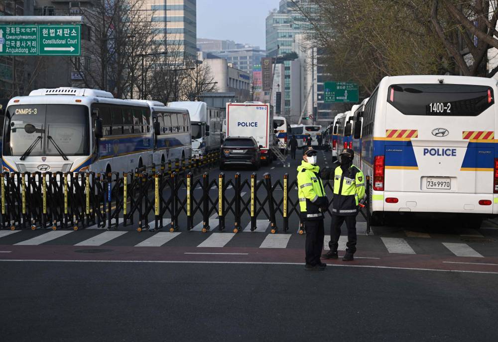 Police officers stand guard in front of a police barricade near the Constitutional Court in Seoul on April 4, 2025, ahead of the long-awaited ruling on South Korean President Yoon Suk Yeol's impeachment. (Photo by Jung Yeon-je / AFP)