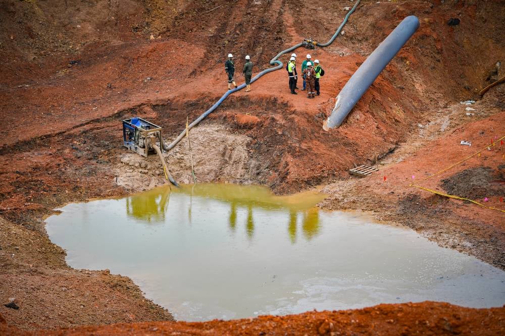 The situation around the explosion and gas pipeline fire site in Putra Heights, today, as efforts to pump water out of the crater at 'ground zero' continue, following several days of rainy weather. - Photo by Bernama