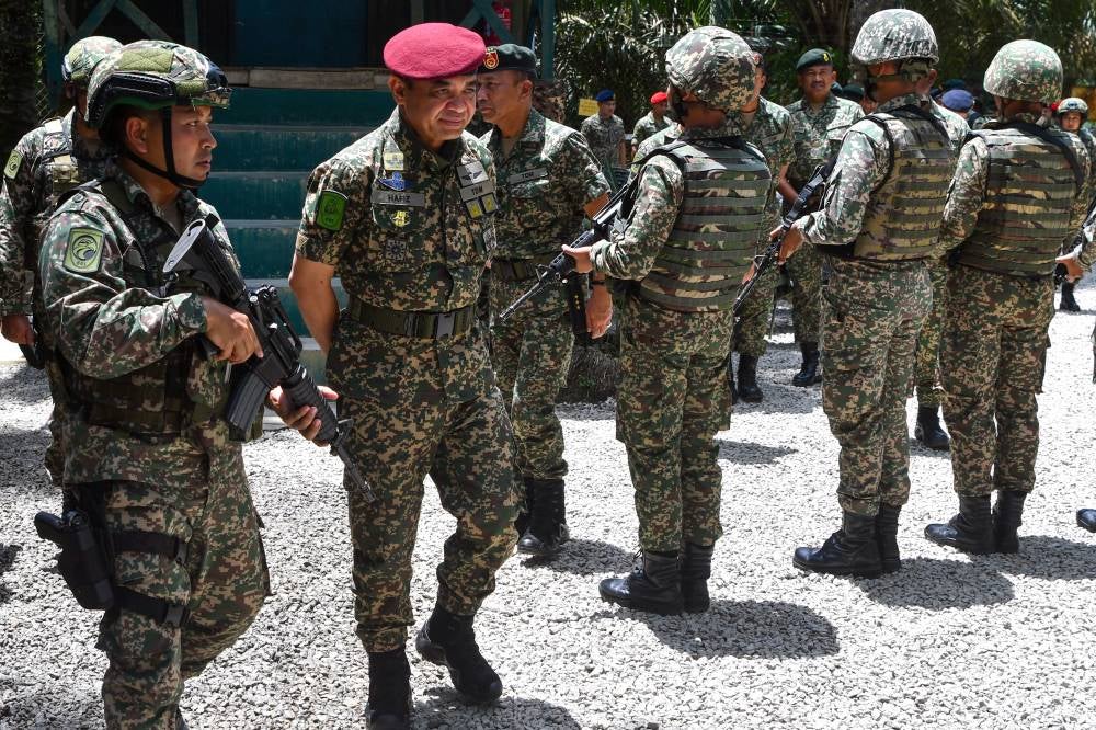 Malaysian Army Chief General Tan Sri Muhammad Hafizuddeain Jantan (two, left) during a visit to the 8th Brigade Operations area in conjunction with the Hari Raya Aidilfitri celebration at the Tok O army post in Rantau Panjang today. - Photo by Bernama