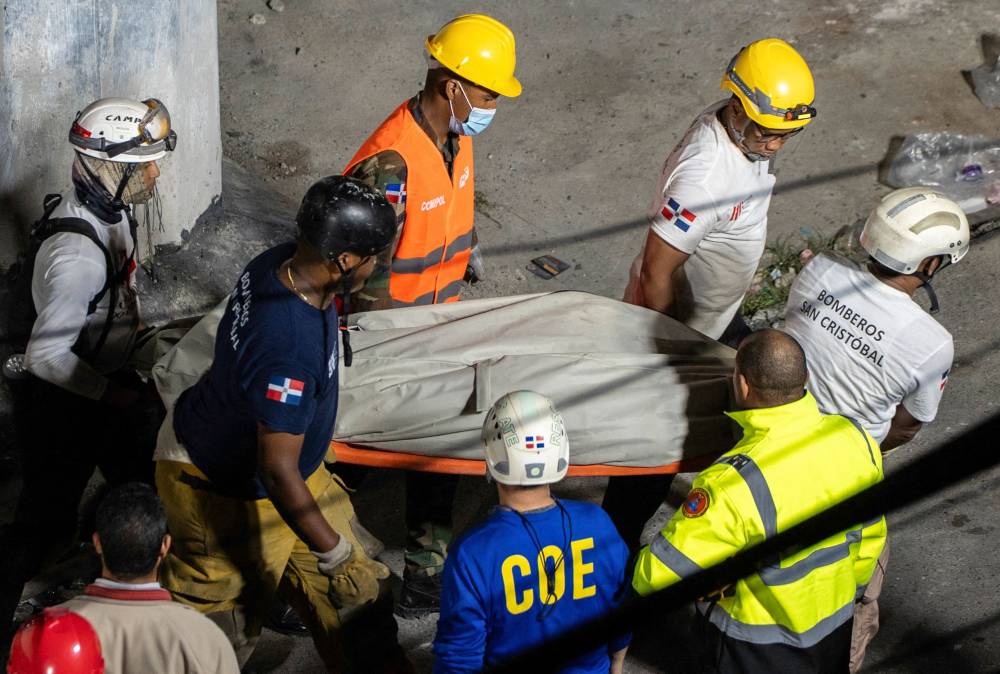 Rescue teams evacuate a body from the Jet Set nightclub following the collapse of its roof in Santo Domingo. Photo by Francesco Spotorno/AFP