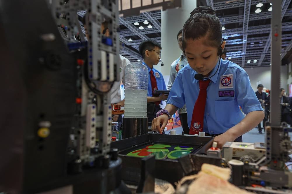 Sekolah Jenis Kebangsaan (C) Jalan Davidson pupils (from left) Yevgen Ngui, 11, Yeoh Zi Jian, 12, and Celeste Tan, 10, proudly showing their own art work using their Marbling Robot For Sustainable Future (MarBot4SF) creation at the Malaysia Open House Exhibition Asean 2025 held in conjunction with the 12th Asean Finance Ministers and Central Bank Governors Meeting (AFMGM) 2025 at the Kuala Lumpur Convention Centre recently. Photo by Bernama