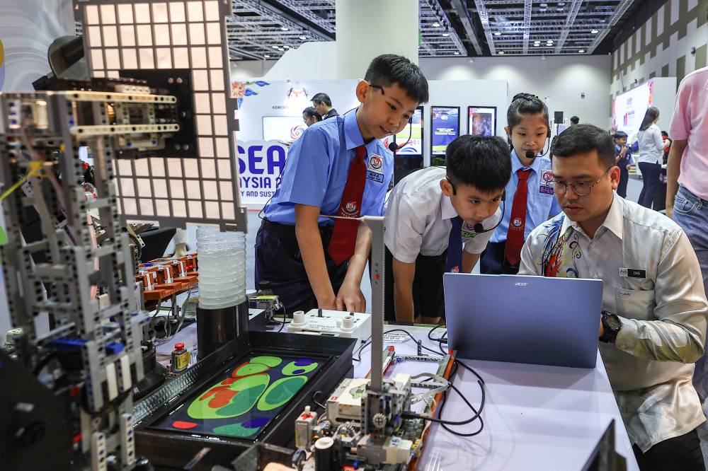 Sekolah Jenis Kebangsaan (C) Jalan Davidson pupils (from left) Yevgen Ngui, 11, Yeoh Zi Jian, 12 and Celeste Tan, 10, created their own art work using their Marbling Robot For Sustainable Future (MarBot4SF) creation at the Malaysia Open House Exhibition Asean 2025 held in conjunction with the 12th Asean Finance Ministers and Central Bank Governors Meeting (AFMGM) 2025 at the Kuala Lumpur Convention Centre recently. Photo by Bernama