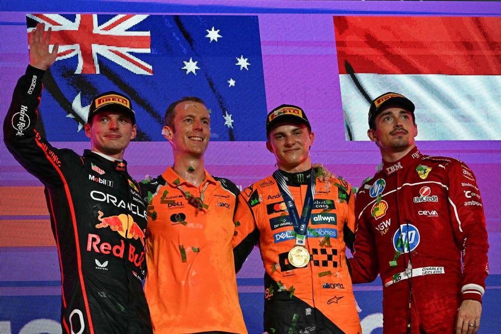 McLaren's Australian driver Oscar Piastri (2R) celebrates on the podium alongside second-placed Red Bull Racing's Dutch driver Max Verstappen (L) and third-placed Ferrari's Monegasque driver Charles Leclerc (R), during the trophy ceremony of the 2025 Saudi Arabia Formula One Grand Prix at the Jeddah Corniche Circuit on April 20, 2025. (Photo by Gabriel BOUYS / AFP)