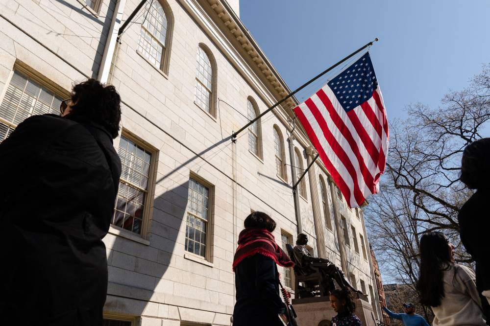 An American flag flies over the John Harvard Statue at Harvard University on April 17, 2025 in Cambridge, Massachusetts. (Photo by Sophie Park / GETTY IMAGES NORTH AMERICA / Getty Images via AFP)