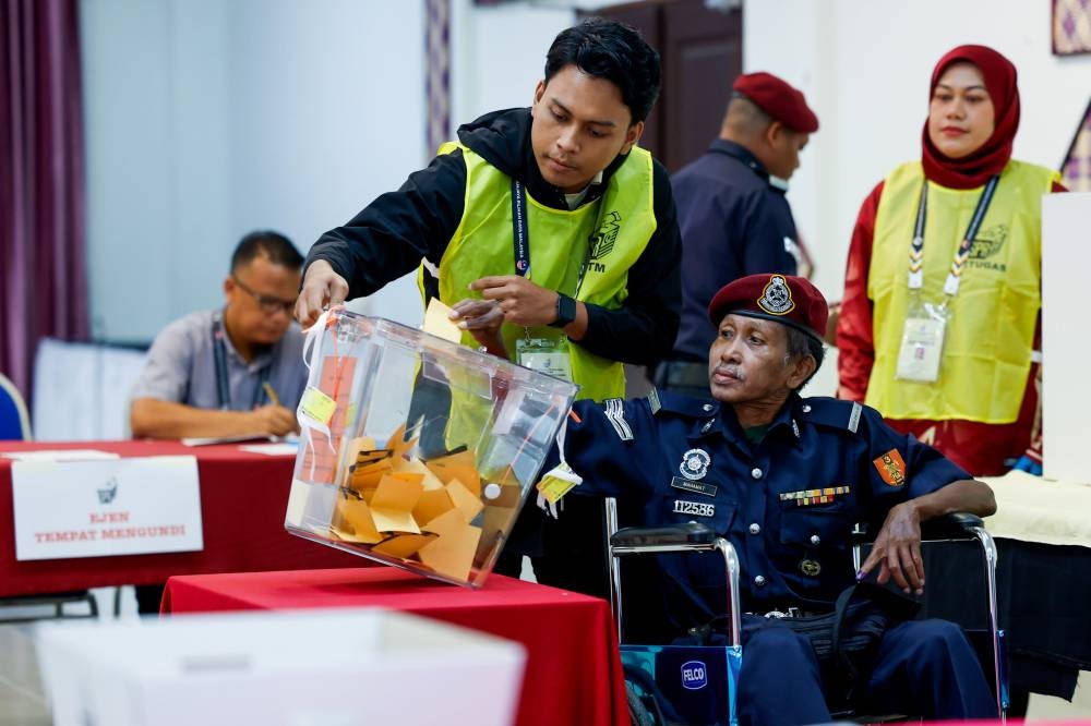 Mahamat was assisted by Election Commission (EC) personnel and completed the voting process by 8.50am. - Bernama photo