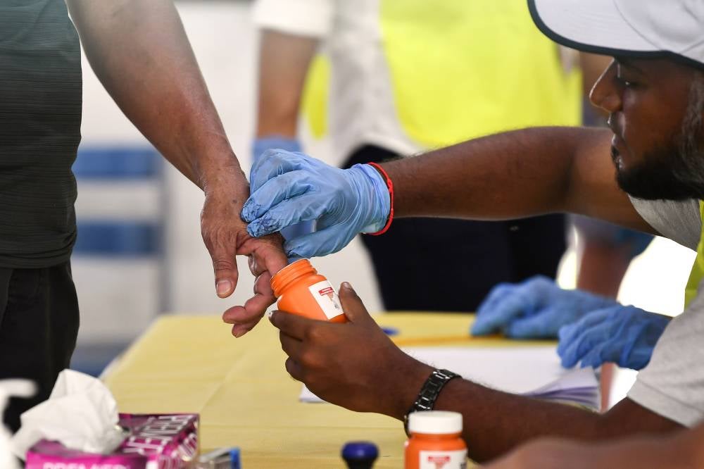 A voter's finger is dipped in ink while voting in the Ayer Kuning State Legislative Assembly (DUN) by-election at the Sungai Kroh Chinese National-Type School polling center today. Photo by Bernama