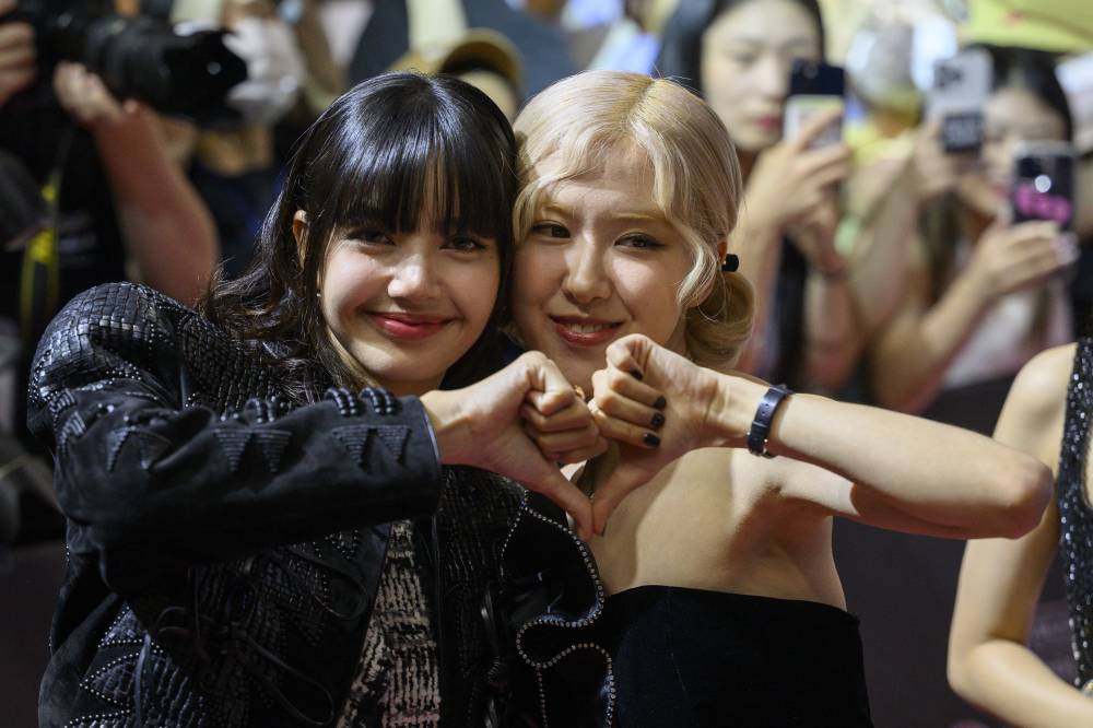Lisa and Rosé (R) from the K-pop girl group BlackPink pose during an event to promote their film 'Born Pink', marking the group's eighth anniversary, in Seoul on Aug 9, 2024. - (Photo by ANTHONY WALLACE / AFP)
