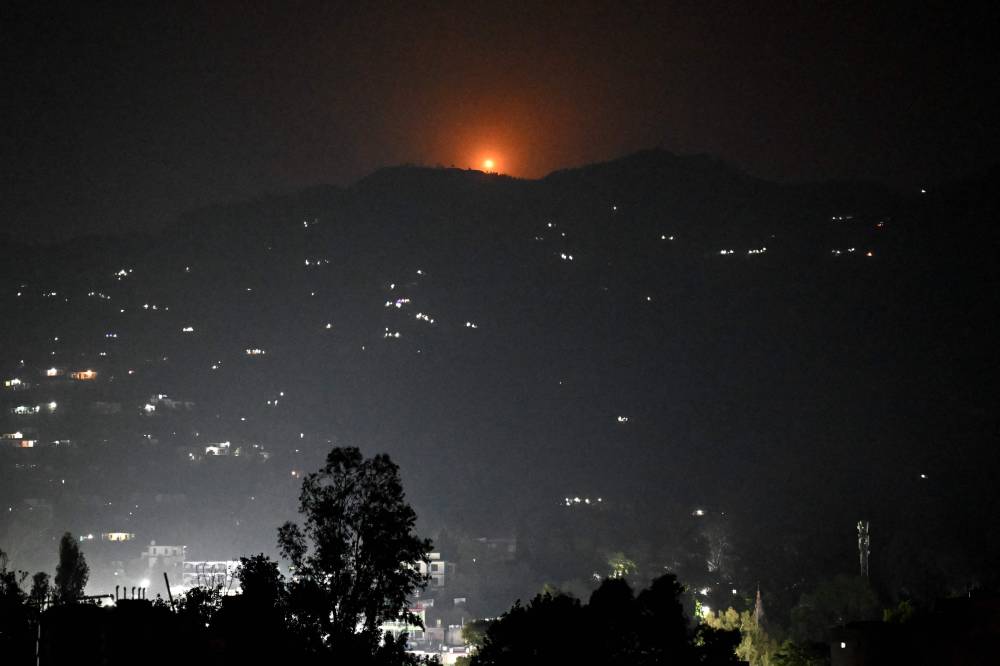 A flare goes up in air over the hill near main town of Poonch district, on May 7, 2025. (Photo by Punit PARANJPE / AFP)