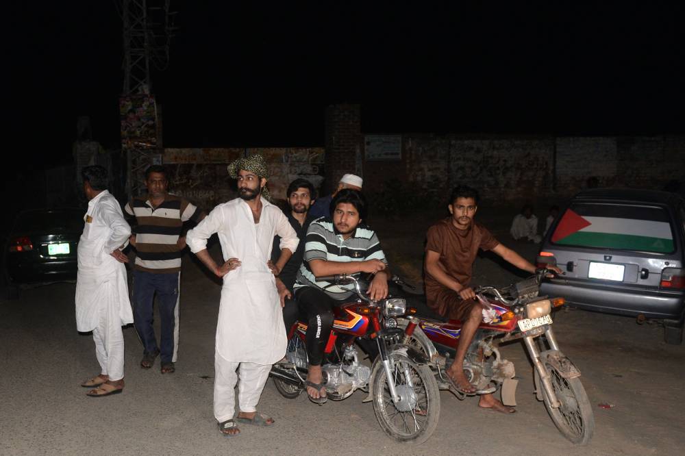 People gather after evacuating their houses as they stand along a street in Muridke, about 30kms from Lahore on May 7, 2025. (Photo by Murtaz Ali / AFP)