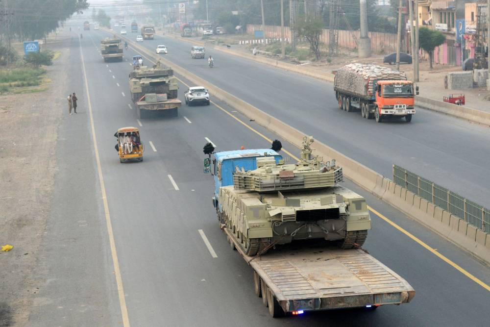 Trucks transport army tanks on a road in Muridke, about 30 kilometres from Lahore, on May 7, 2025. India fired missiles at Pakistani territory early on May 7, killing at least eight people, according to Pakistan, which said it had begun retaliating in a major escalation between the nuclear-armed rivals. (Photo by Murtaz Ali / AFP)