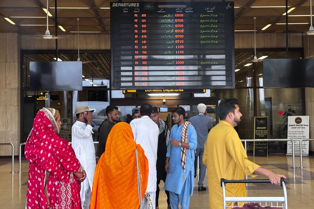 Passengers wait at Jinnah International airport after all domestic and international flights were cancelled in Karachi on May 7, 2025. (Photo by Asif HASSAN / AFP)