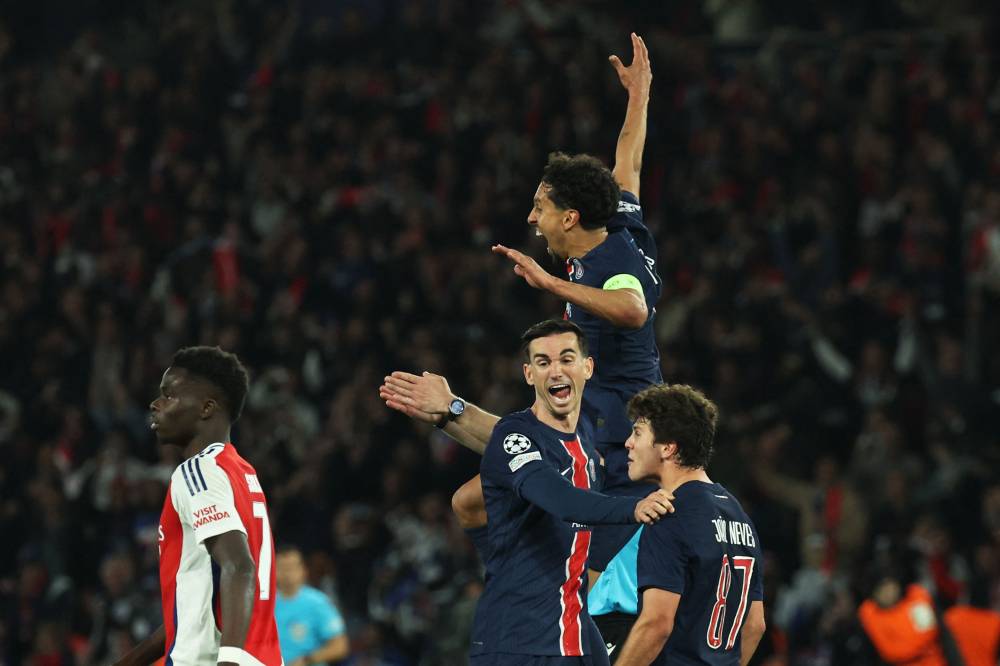 Paris Saint-Germain's Portuguese midfielder #87 Joao Pedro Goncalves Neves (R), Paris Saint-Germain's Brazilian defender #05 Marquinhos (2nd R), and Paris Saint-Germain's Spanish midfielder #08 Fabian Ruiz (C) celebrate their victory next to Arsenal's English forward #07 Bukayo Saka (L) at the end of the UEFA Champions League semi-final second leg football match between Paris Saint-Germain (PSG) and Arsenal at the Parc des Princes stadium in Paris, on May 7, 2025. (Photo by Thomas SAMSON / AFP)