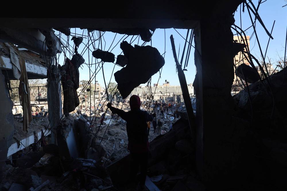 Palestinians check the destruction at a UNRWA school housing displaced people, following an Israeli strike in the Bureij refugee camp in the centre of the Gaza Strip, on May 7, 2025. (Photo by Eyad BABA / AFP)